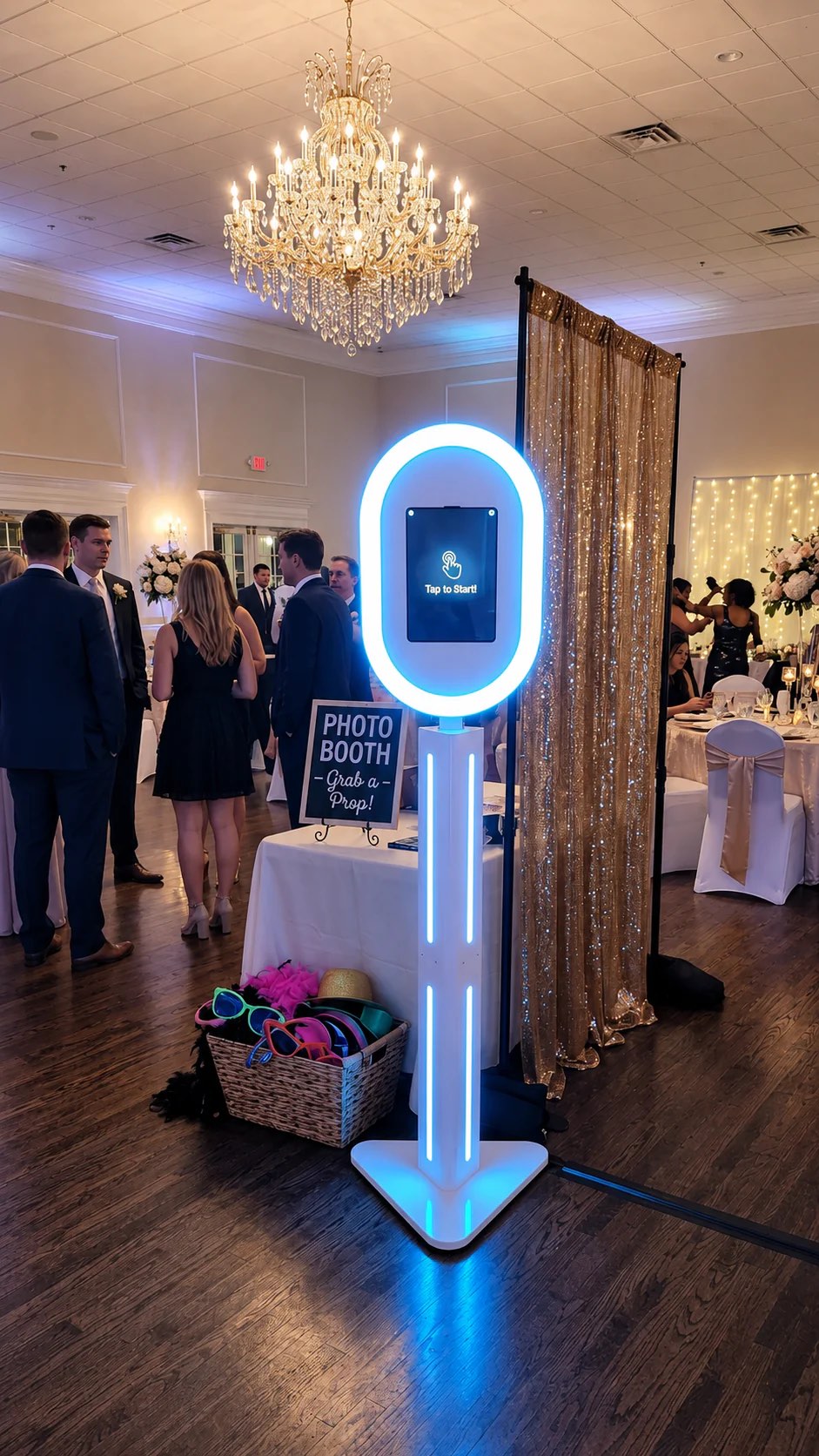 An Advanced Entertainment LED photo booth set up at a ballroom reception, with a prop basket and a sequin backdrop